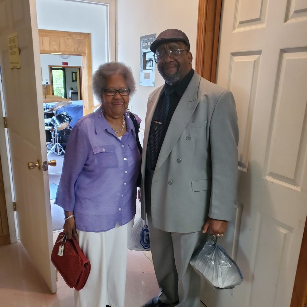 A mother of the church and a deacon at the sanctuary door on Sunday morning
