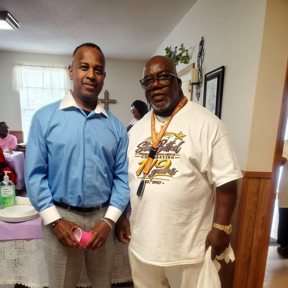 Two members of Star Bethel greeting one another in the fellowship hall