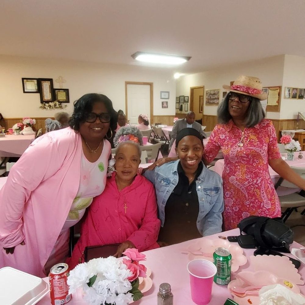Ladies of the church seated around a decorated fellowship table