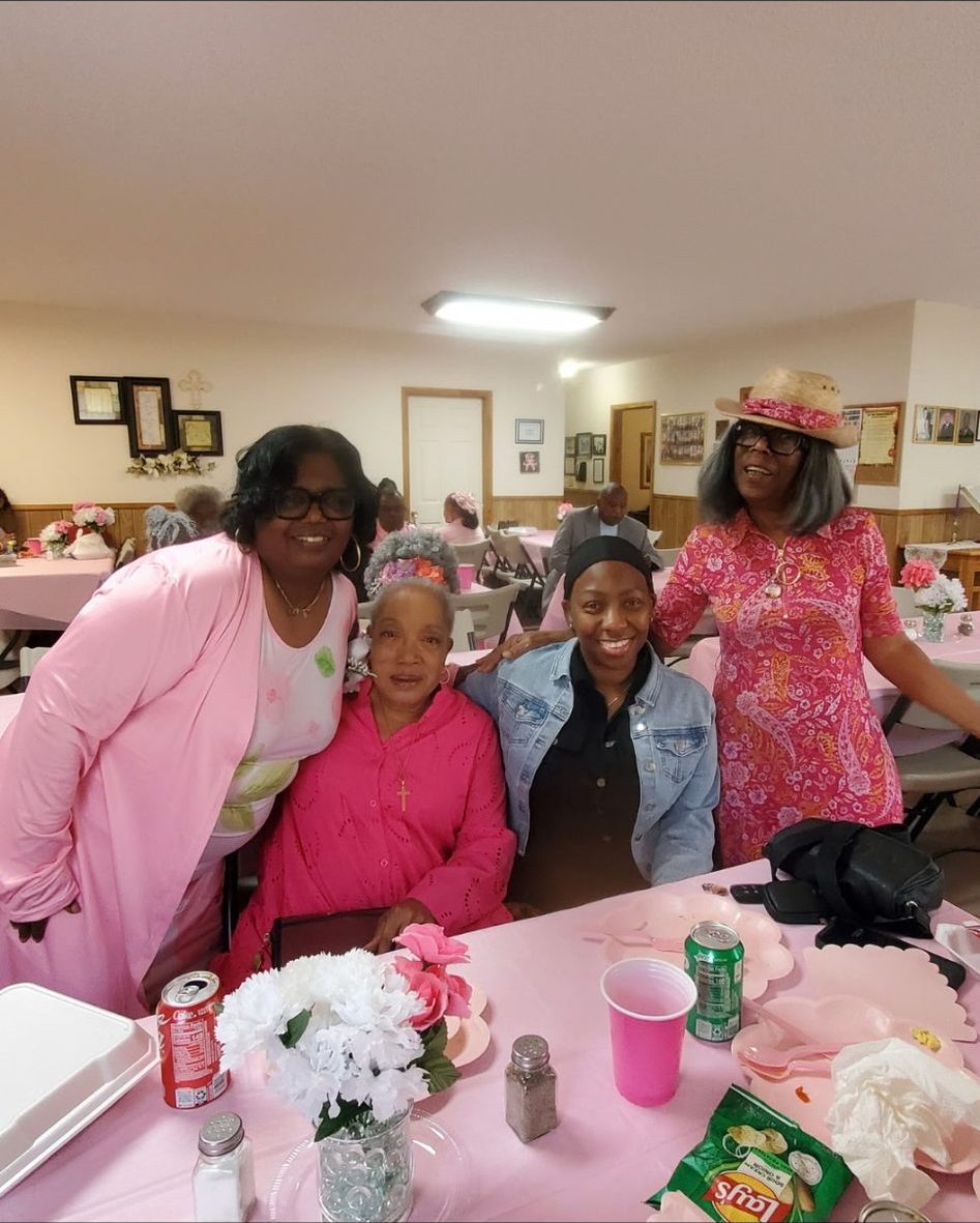 Ladies of the church seated around a decorated fellowship table
