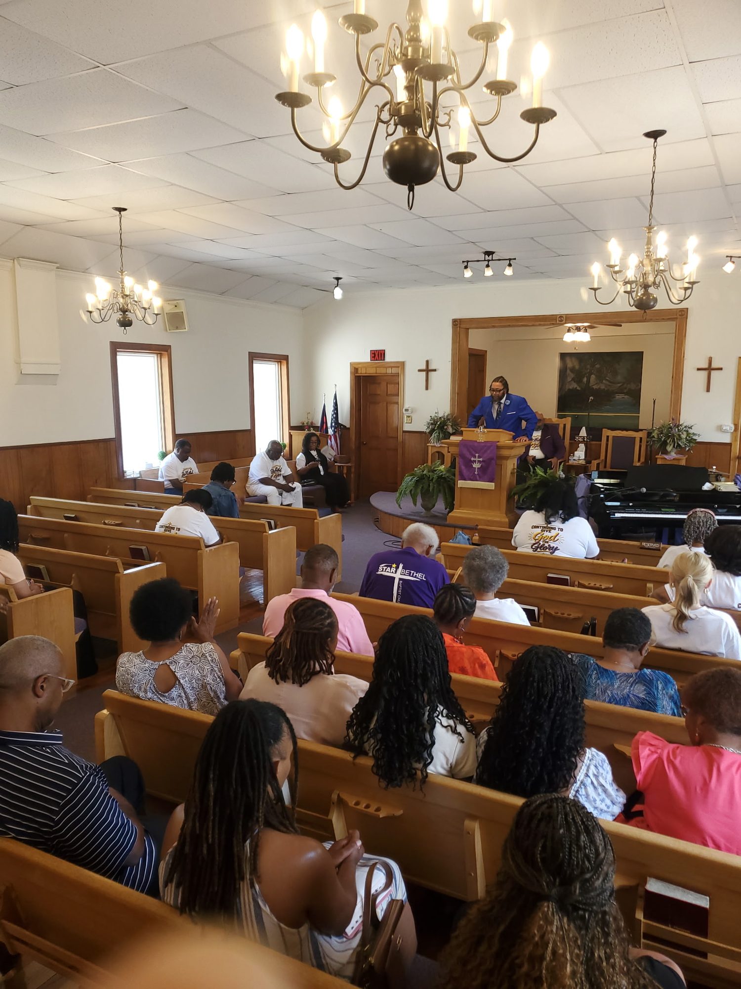 The congregation in worship under the sanctuary chandeliers
